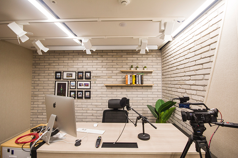 책상과 의자, 컴퓨터, 스피커, 카메라, 마이크, 조명 등이 구비된 1인 스튜디오 사진