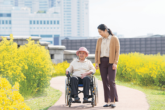 An elderly person and a helper traveling in a wheelchair