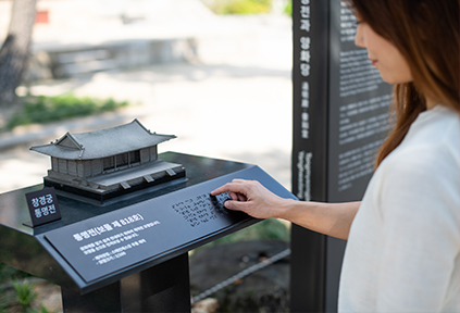 A visitor with a visual impairment checking information on Tongyeongjeon Hall in Changgyeonggung Palace in Braille